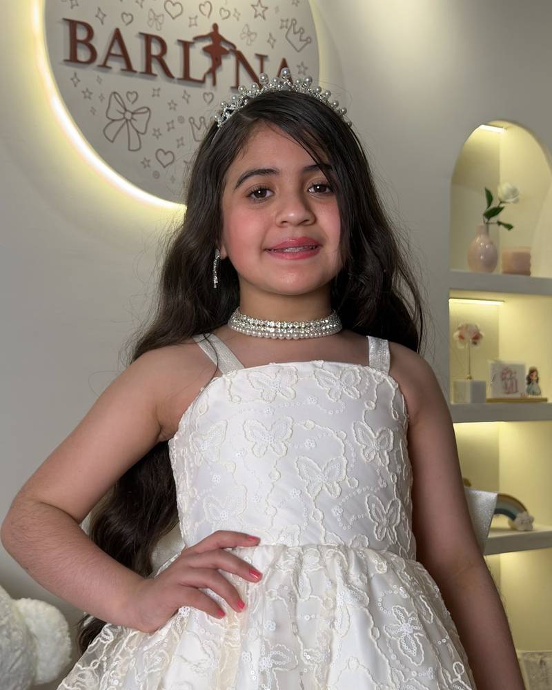 short off-white girl's dress with a bow at the back