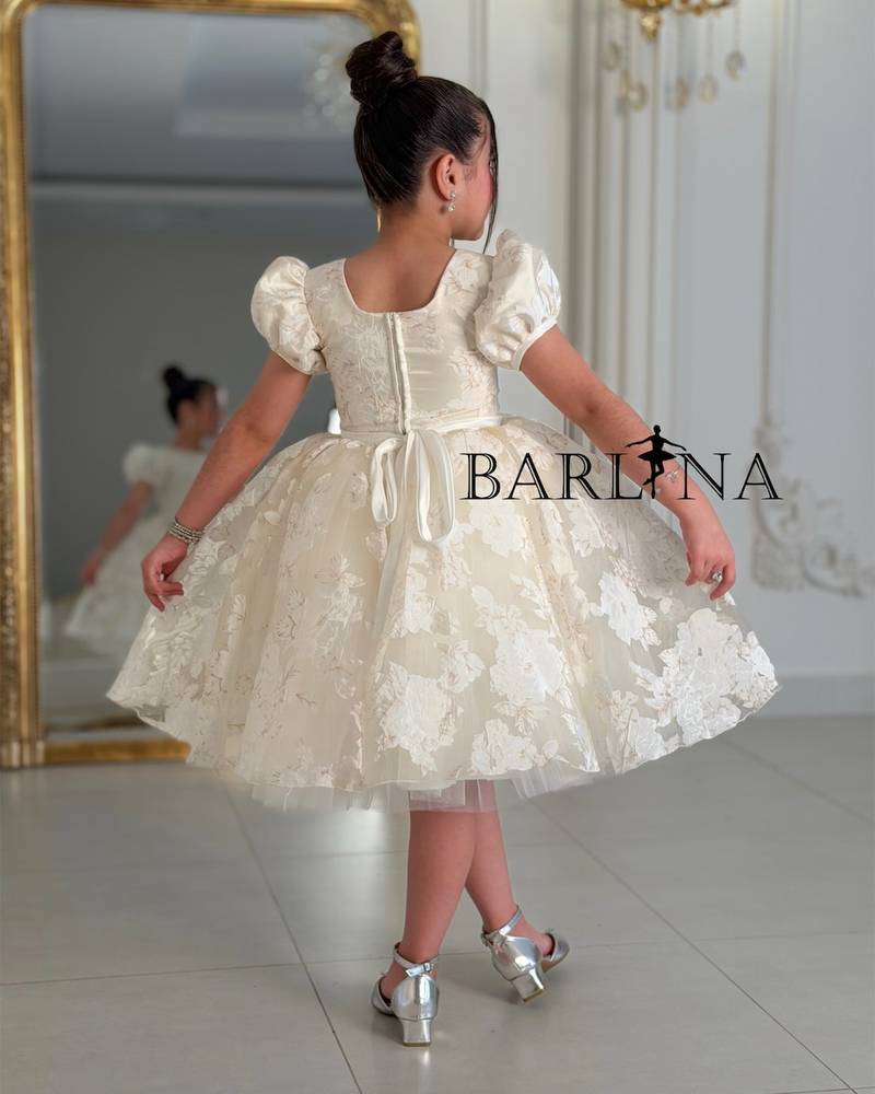 A puffy, off-white girl's dress with a floral print