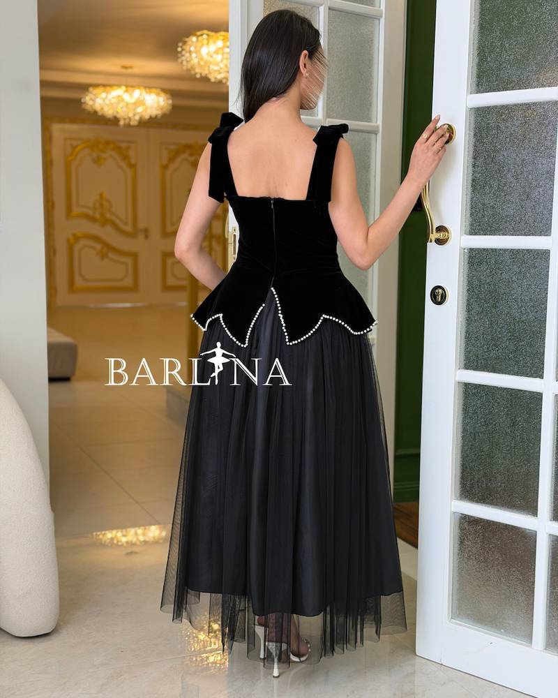 A black dress with a corset silhouette and pearl accents.