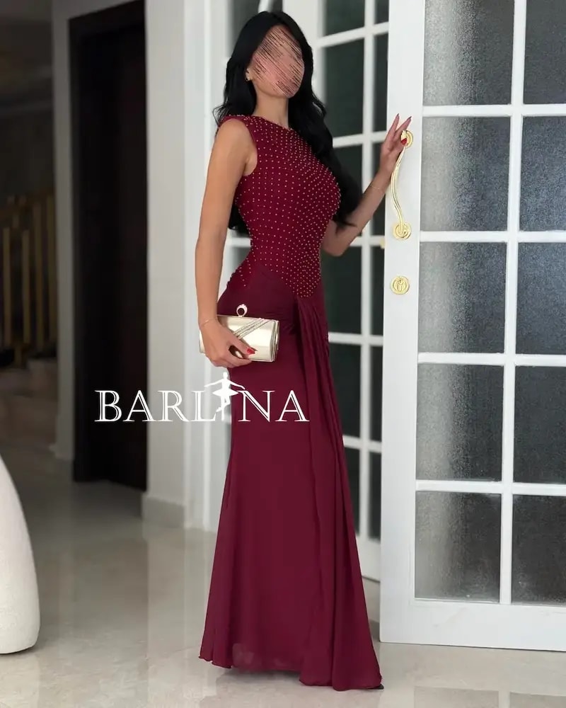 A red dress with shimmering embroidery and a flowing silhouette.
