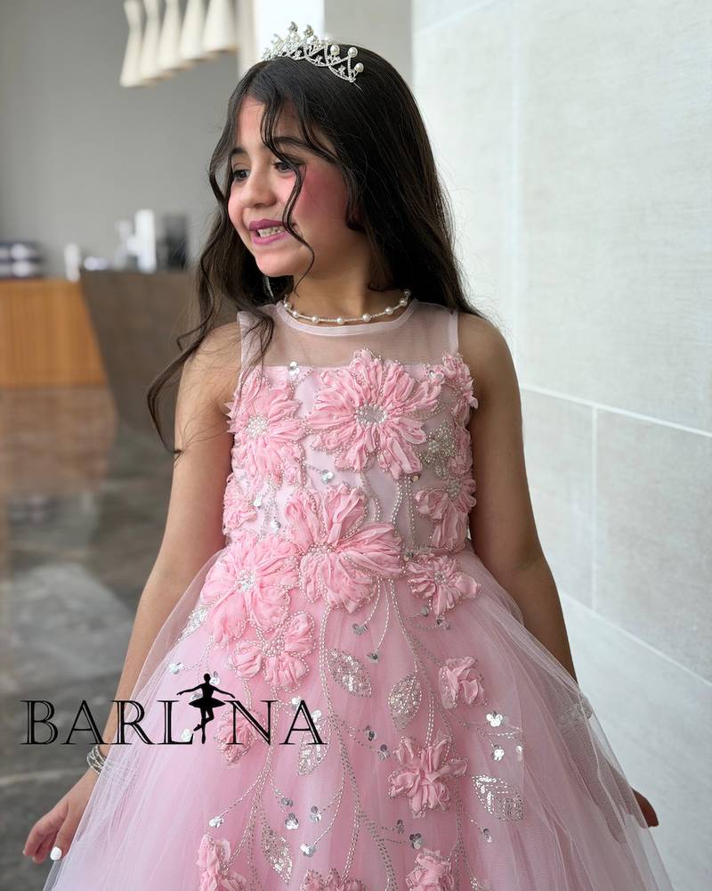 Pink girl's dress decorated with flowers and sparkly embroidery