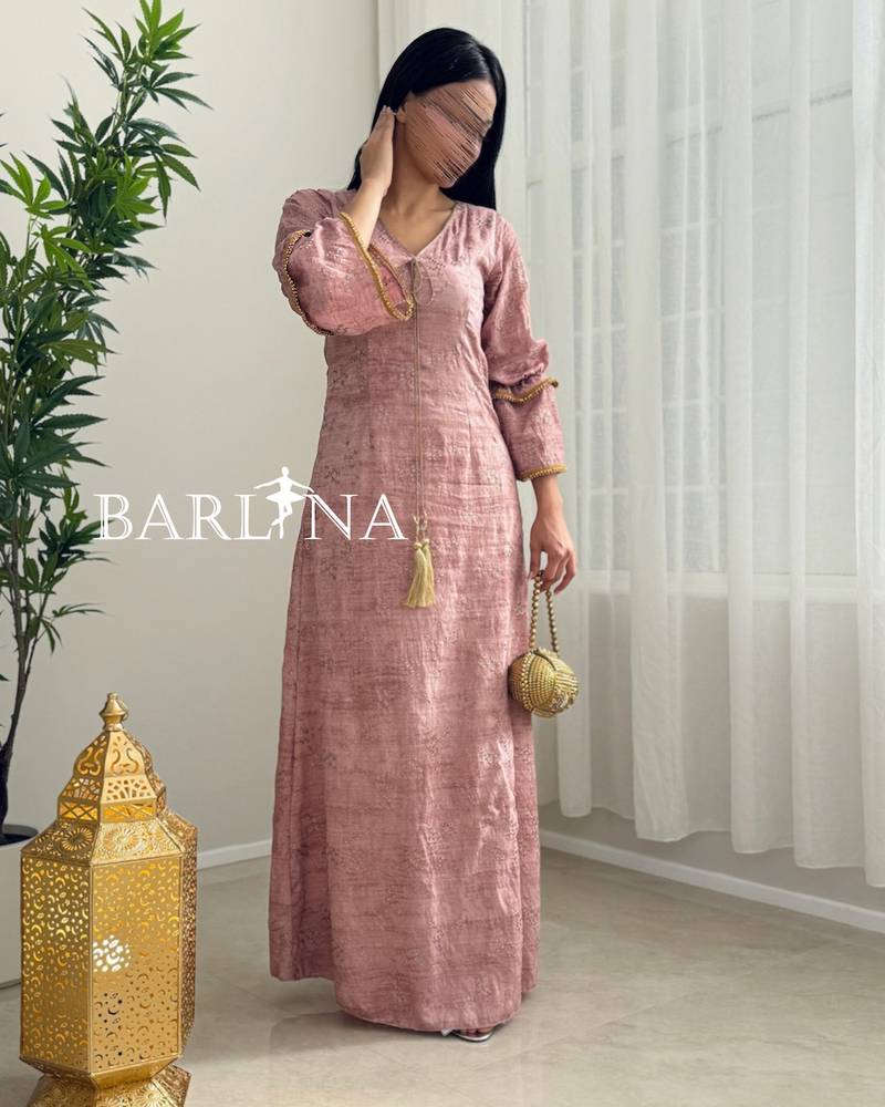 A soft pink jalabiya with gold trim