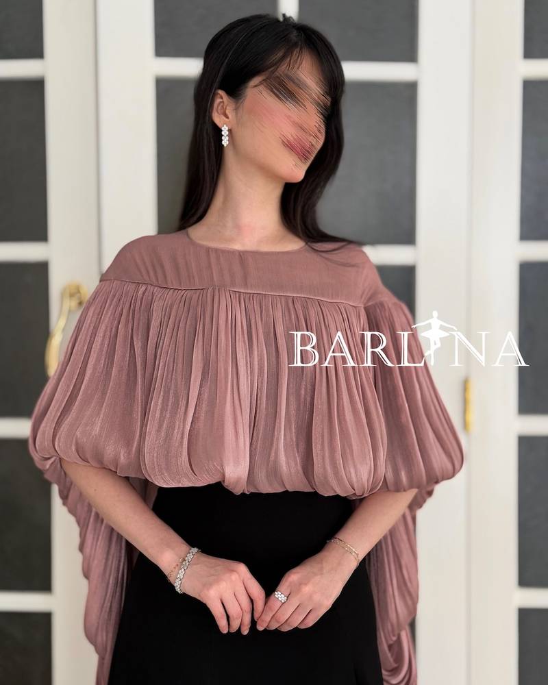 Black dress with a long pink pleated shawl cape