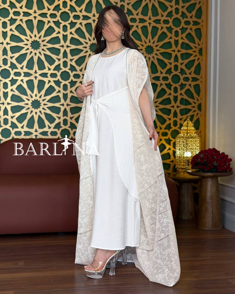 A soft white jalabiya with a sheer lace overlay.