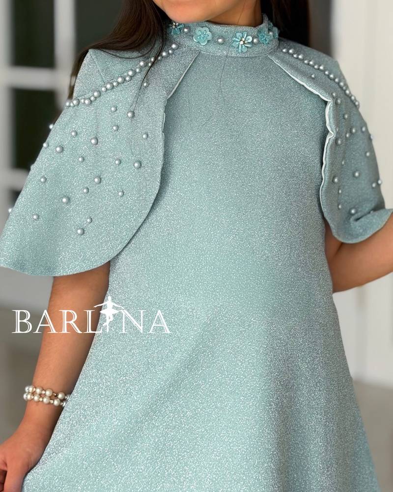 A shiny dress with a straight cut and a ruffled hem.