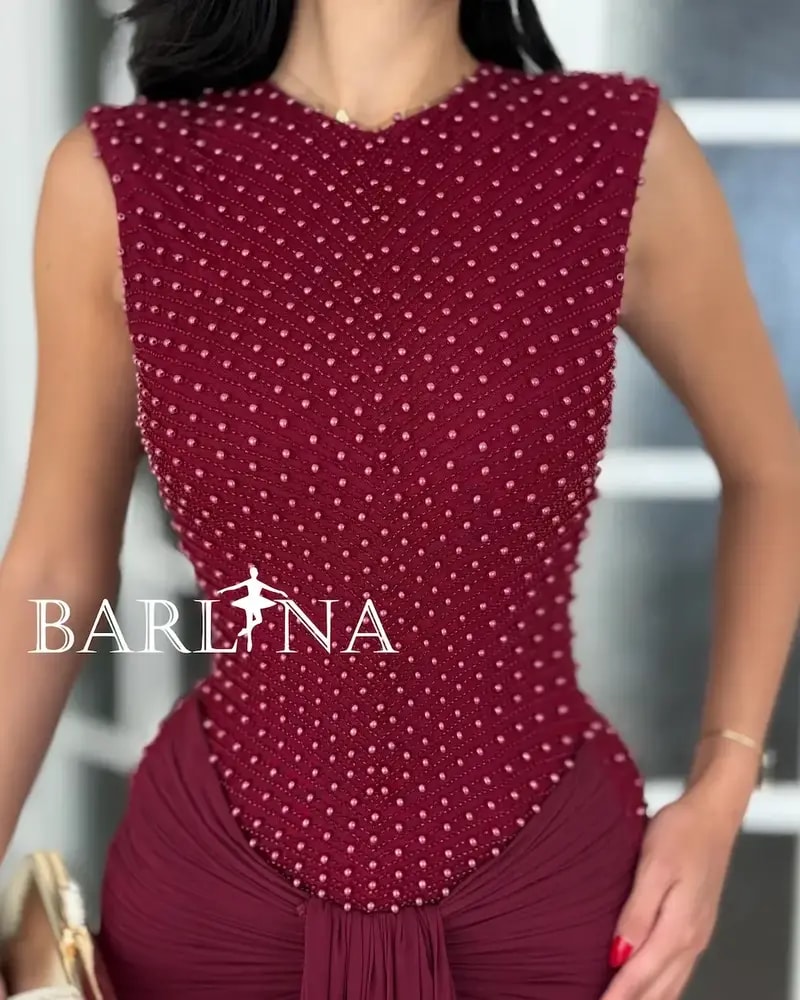 A red dress with shimmering embroidery and a flowing silhouette.