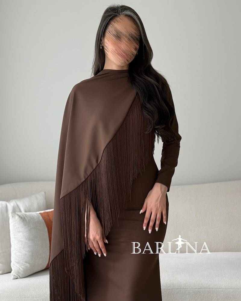A brown dress with a wrapped cape adorned with fringes