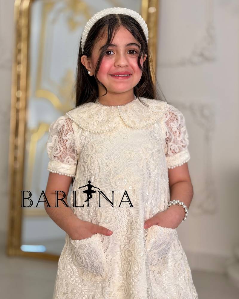 A soft girl's dress with lace and feather trim
