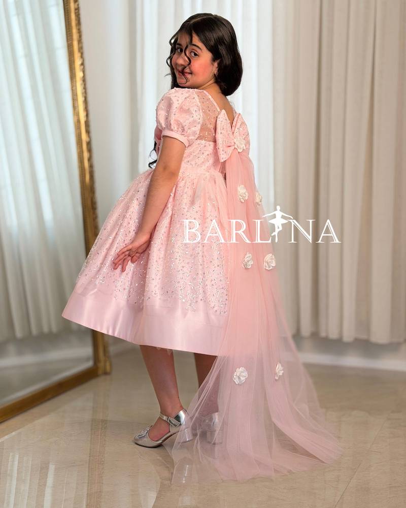 A shiny pink girl's dress decorated with sparkly details