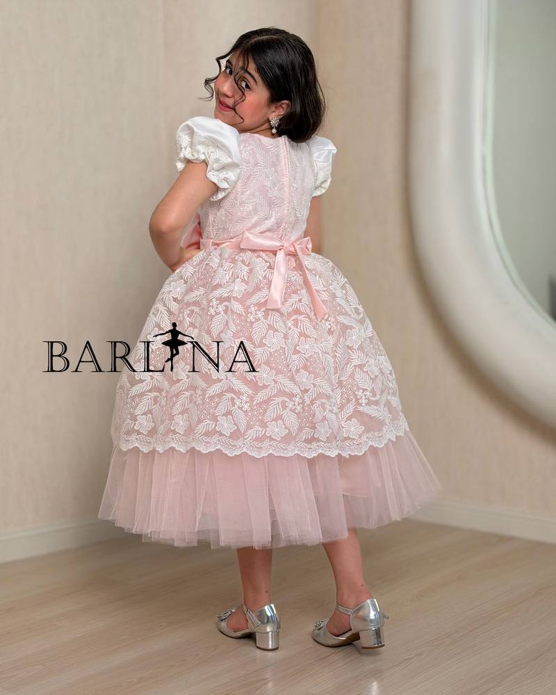 Pink girl's dress decorated with a bow and lace