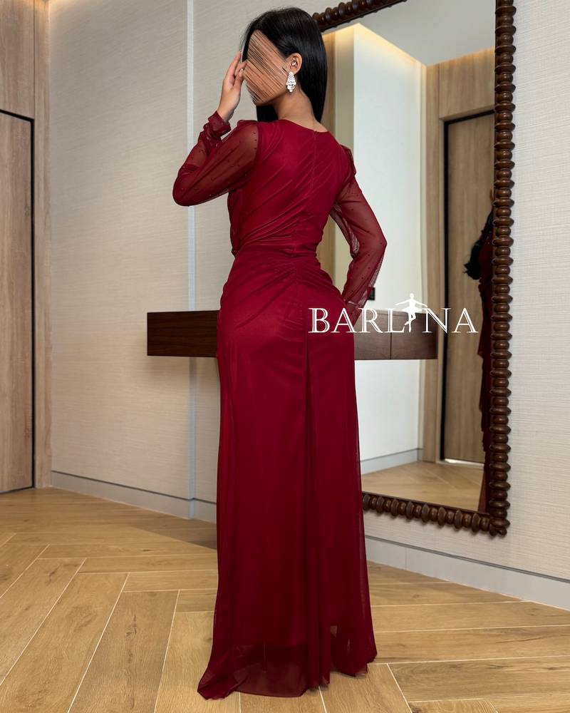 Burgundy dress with sheer sleeves and a draped design