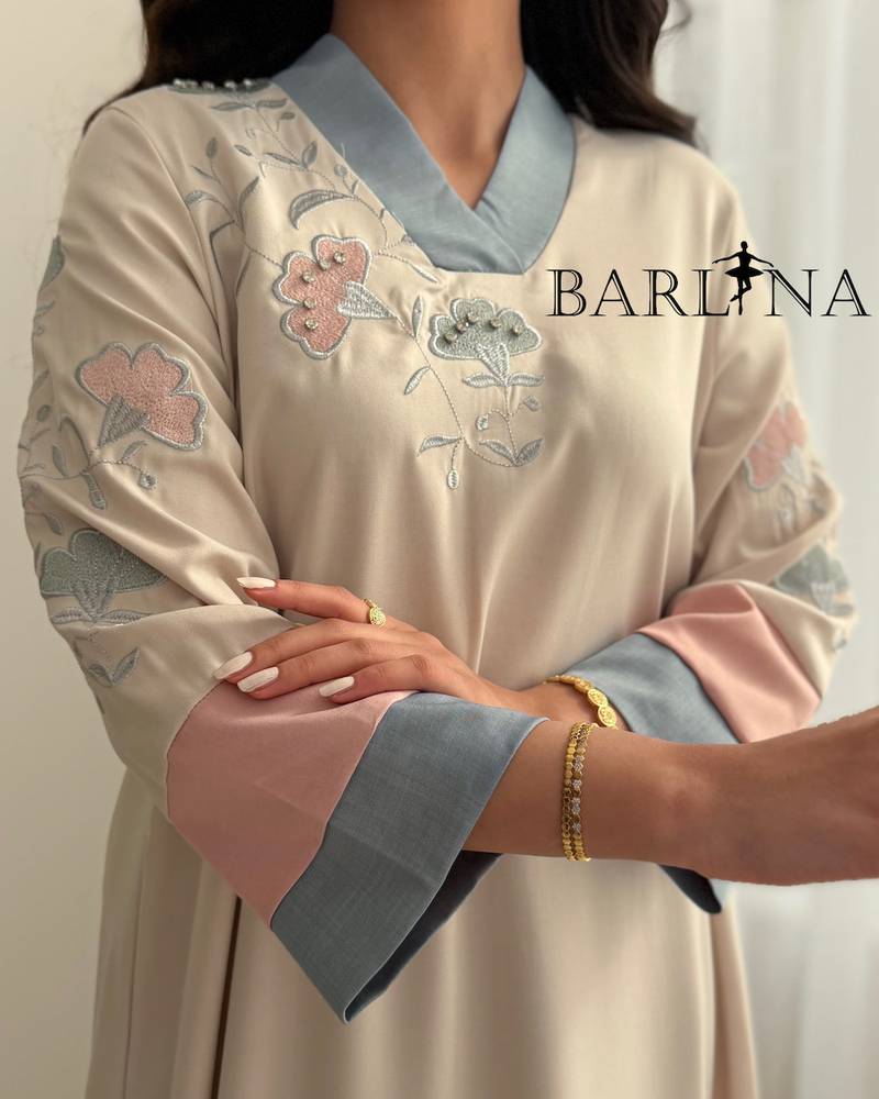 Cream-colored jalabiya with delicate embroidery and colored edges