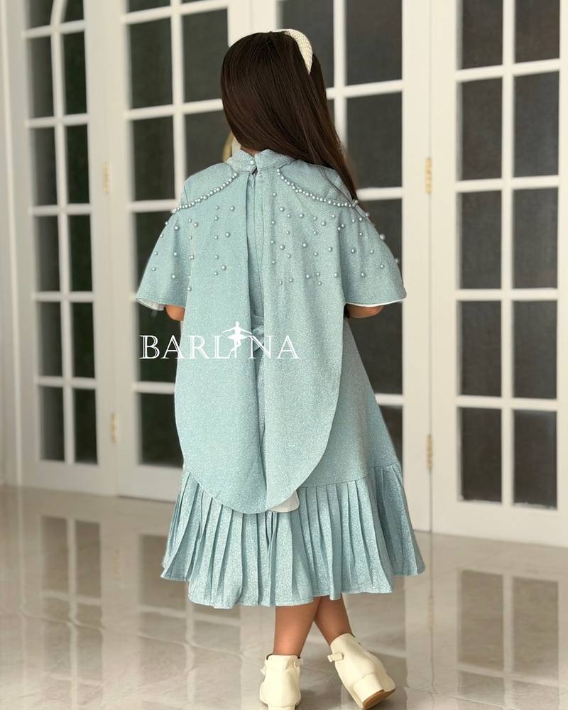 A shiny dress with a straight cut and a ruffled hem.