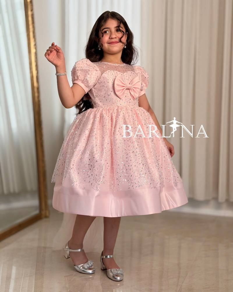 A shiny pink girl's dress decorated with sparkly details