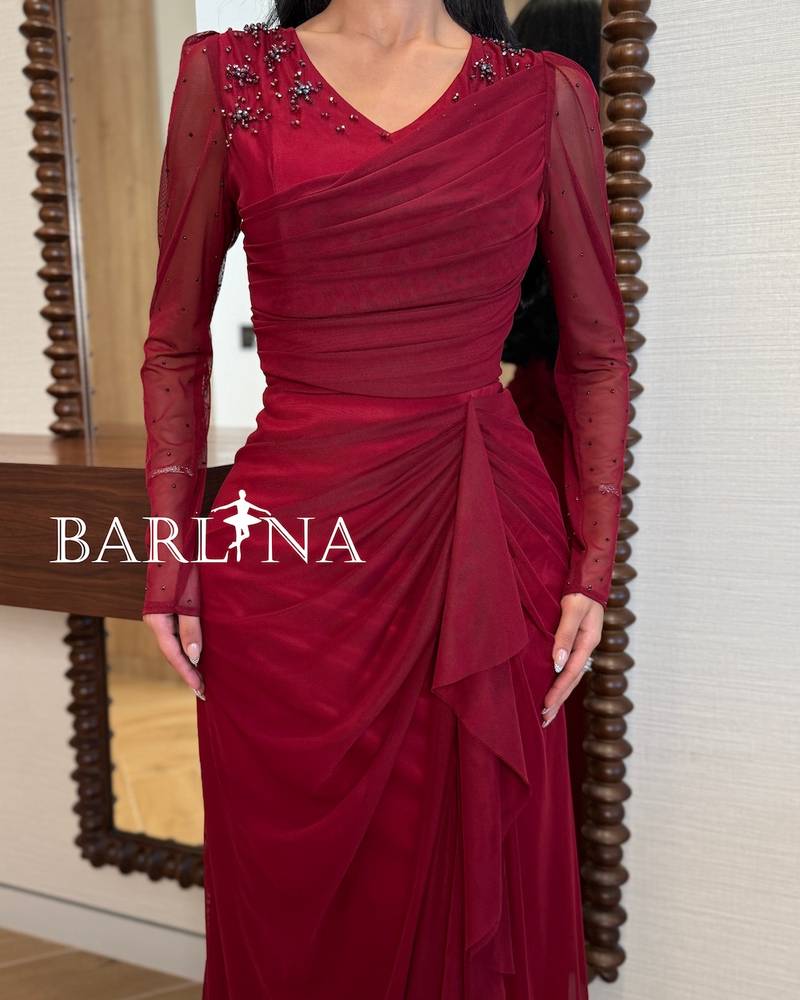 Burgundy dress with sheer sleeves and a draped design