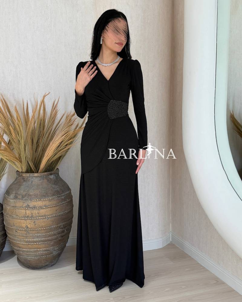 A black wrap dress with an elegant brooch