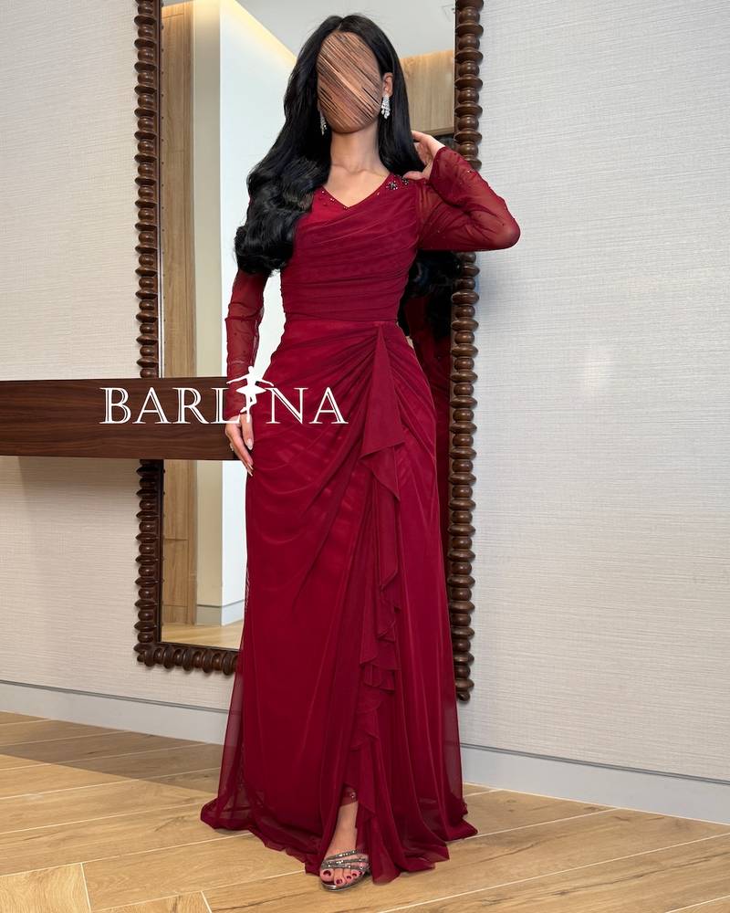 Burgundy dress with sheer sleeves and a draped design