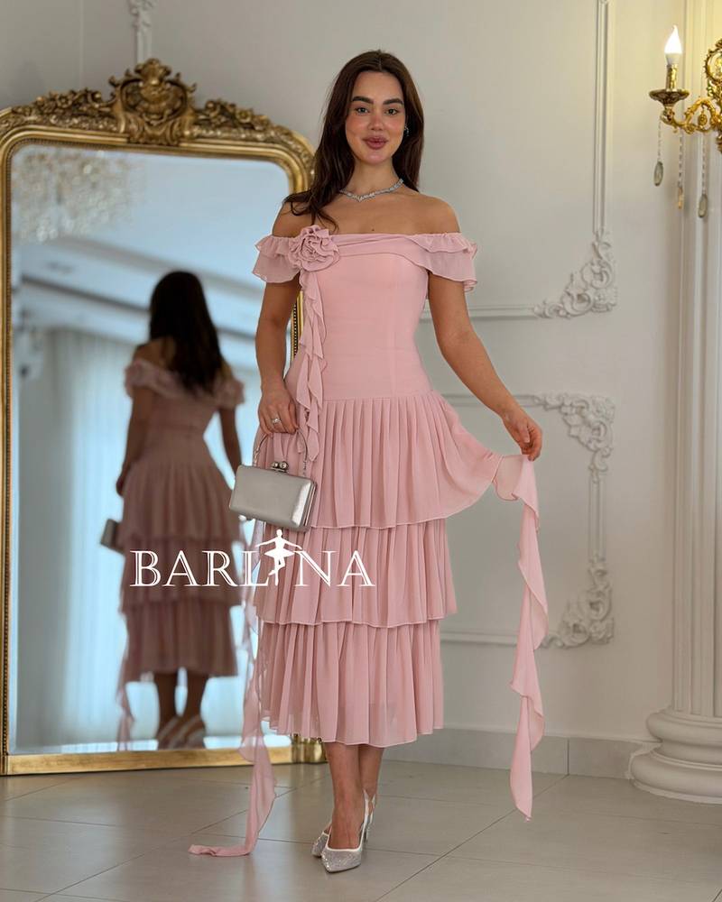 A soft, layered dress with a fabric rose.