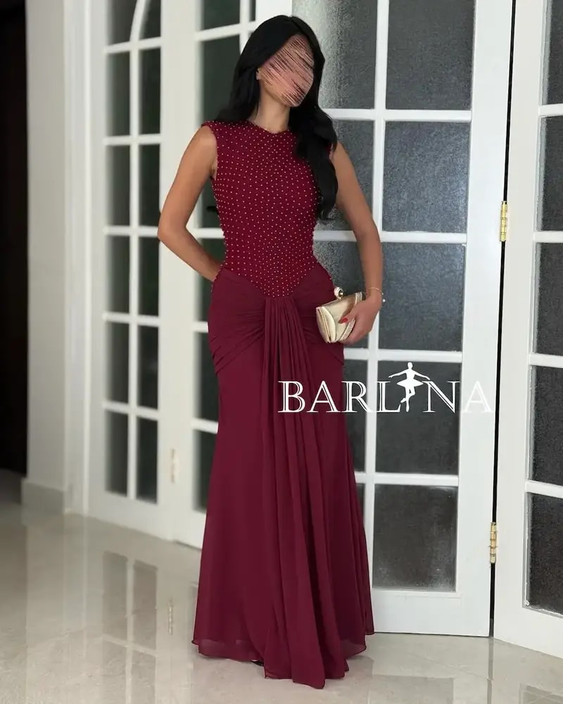 A red dress with shimmering embroidery and a flowing silhouette.