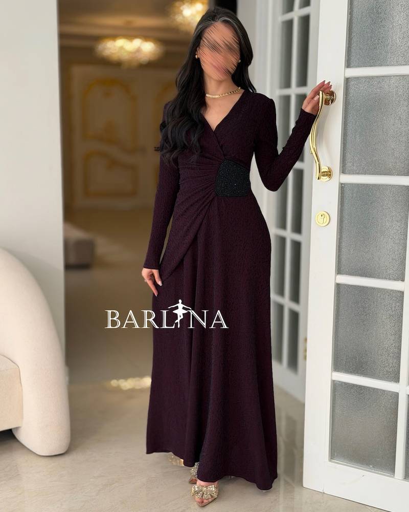 A long burgundy dress with a decorative beaded detail