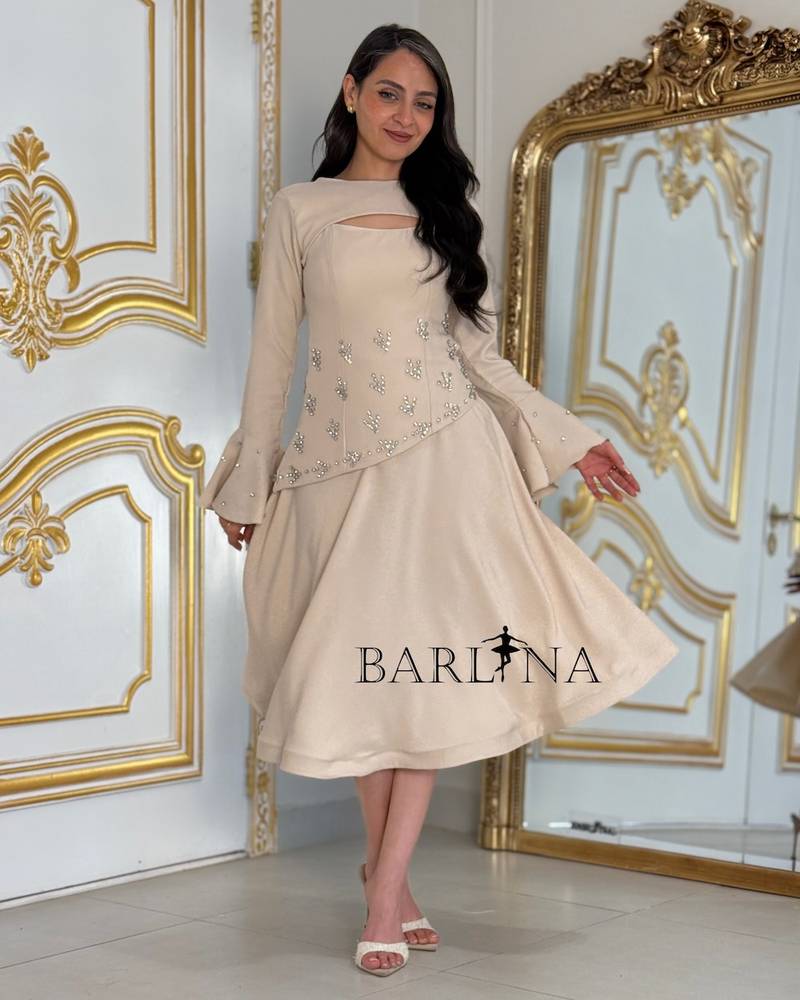 Beige dress adorned with crystals and a piece on the sleeve