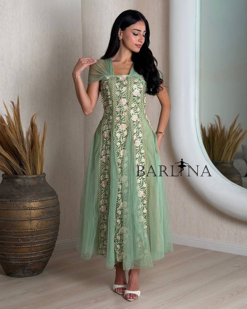 Green dress with tulle sleeves and rose embroidery