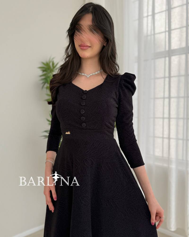 A black dress with a wide cut and elegant buttons