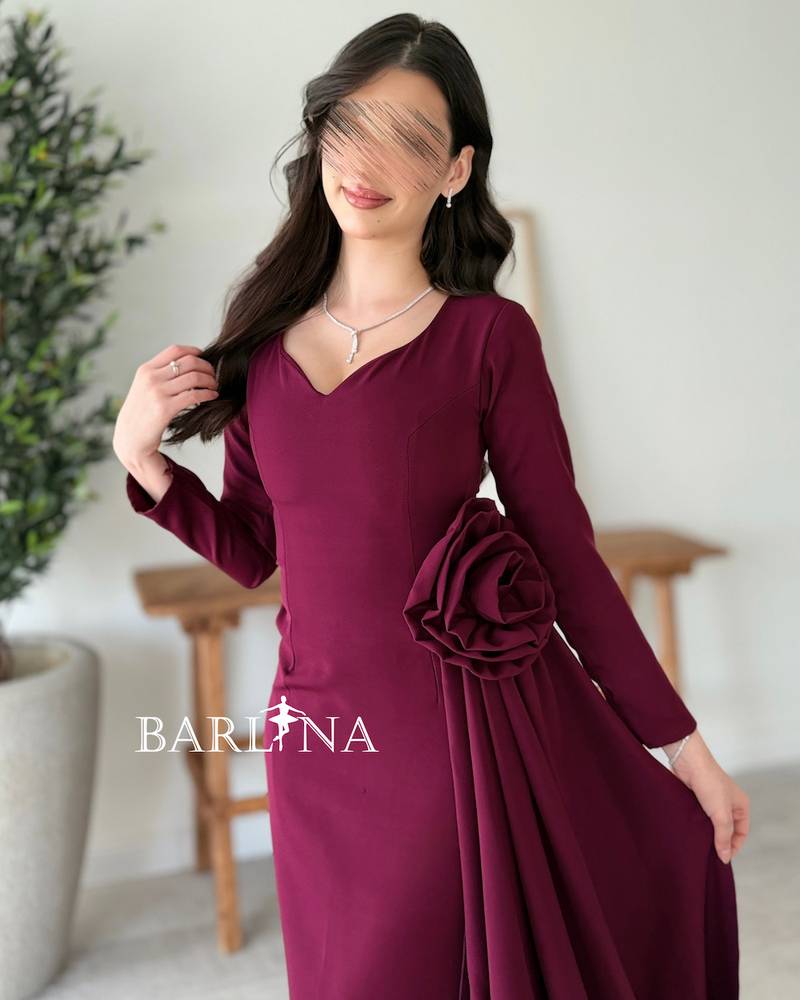 A purple dress adorned with a side flower and a long train.