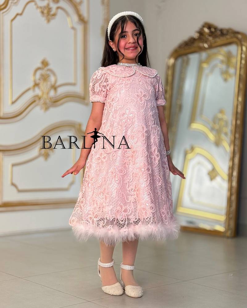 A soft girl's dress with lace and feather trim
