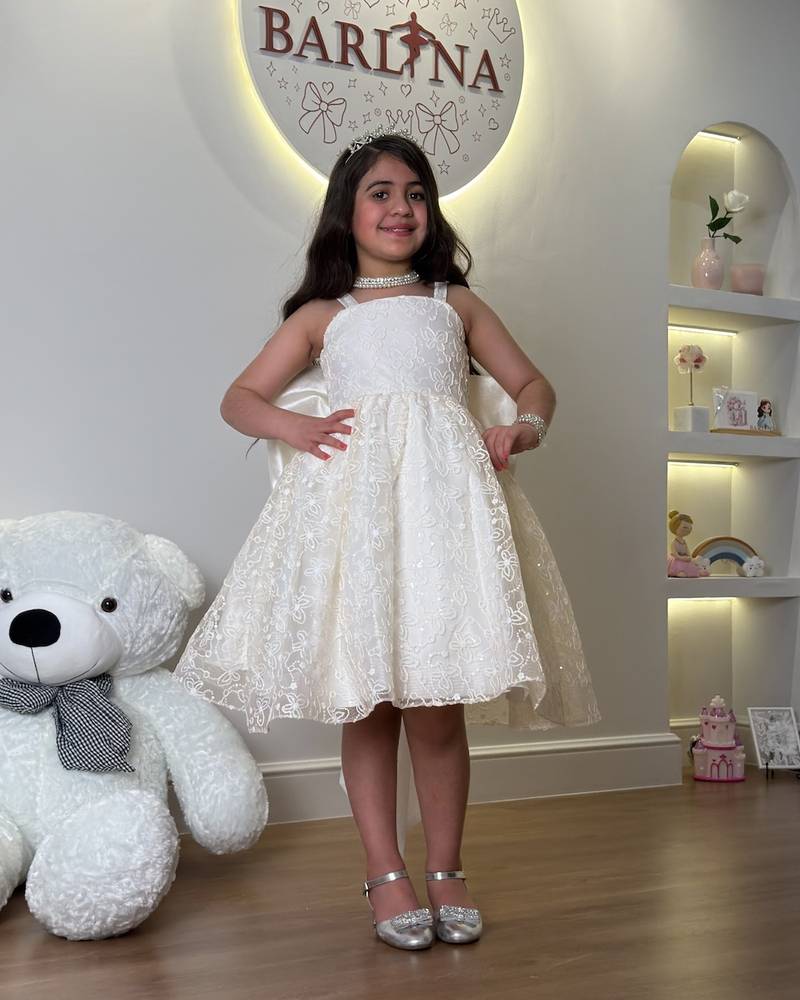 short off-white girl's dress with a bow at the back