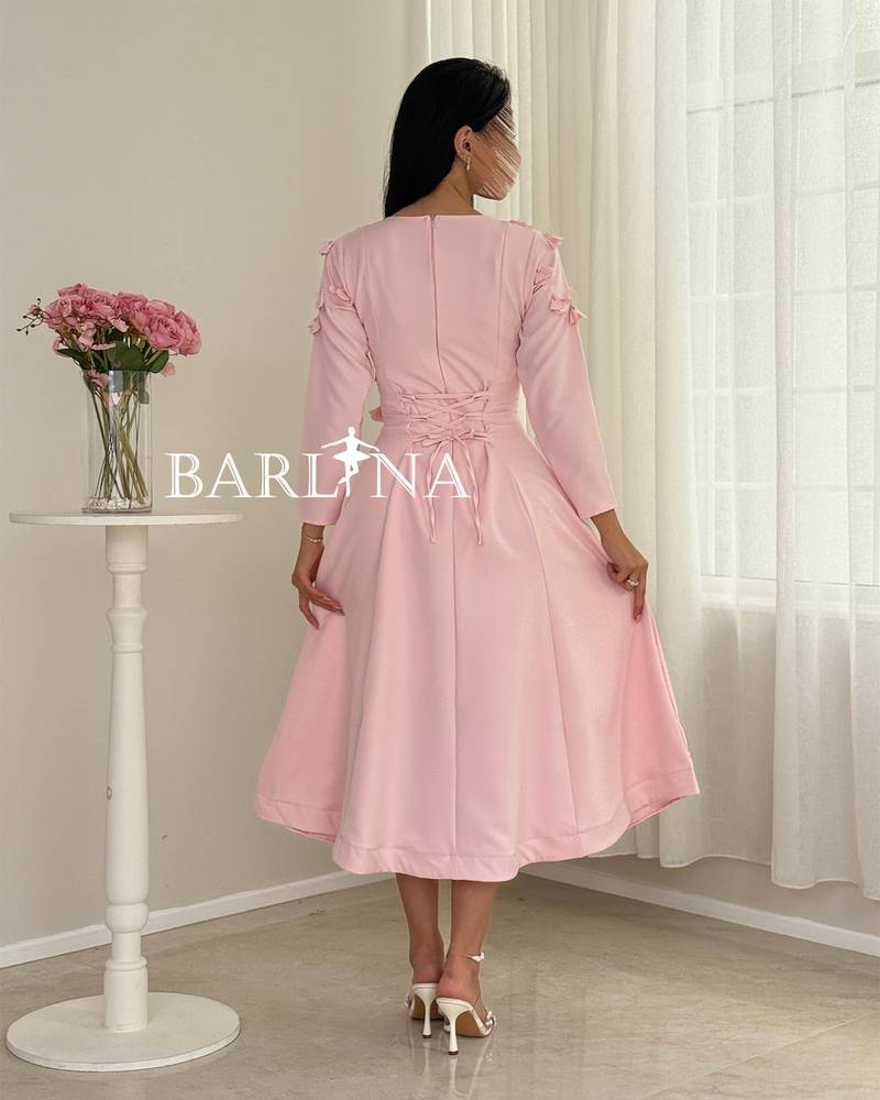 A soft pink midi dress with a sophisticated, feminine cut.