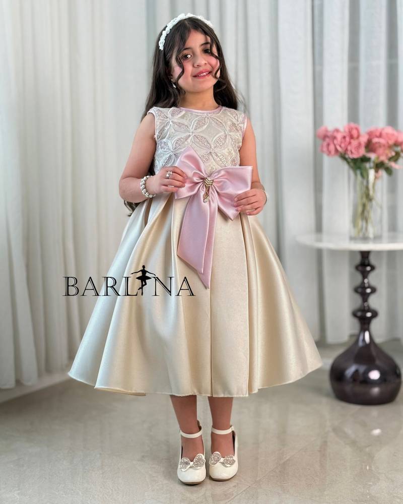 Beige girl's dress decorated with a pink bow