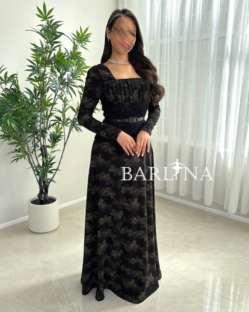 A soft black dress with a subtle pattern and a thin belt