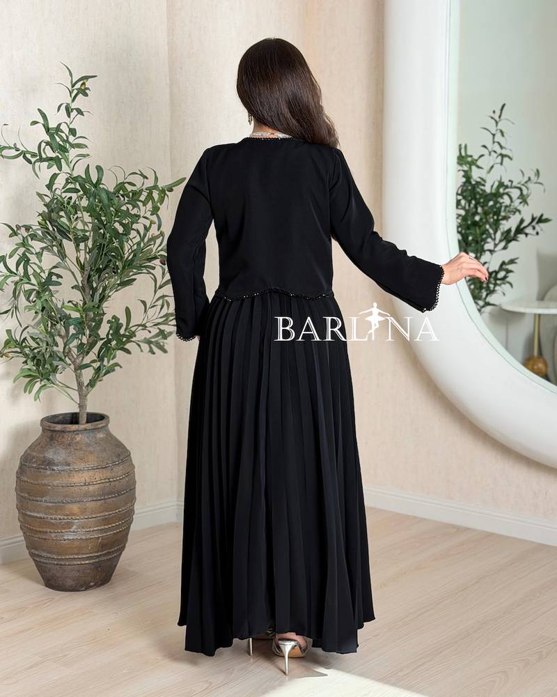 Black pleated dress and embroidered jacket