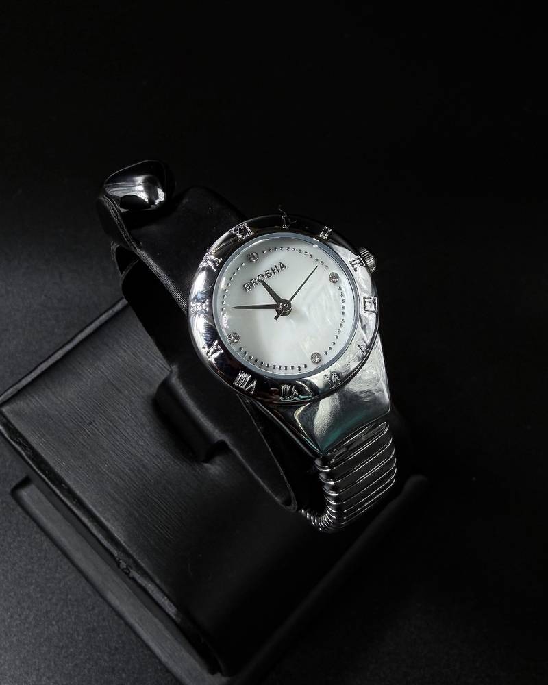 A women's watch with a delicate design and an open strap.