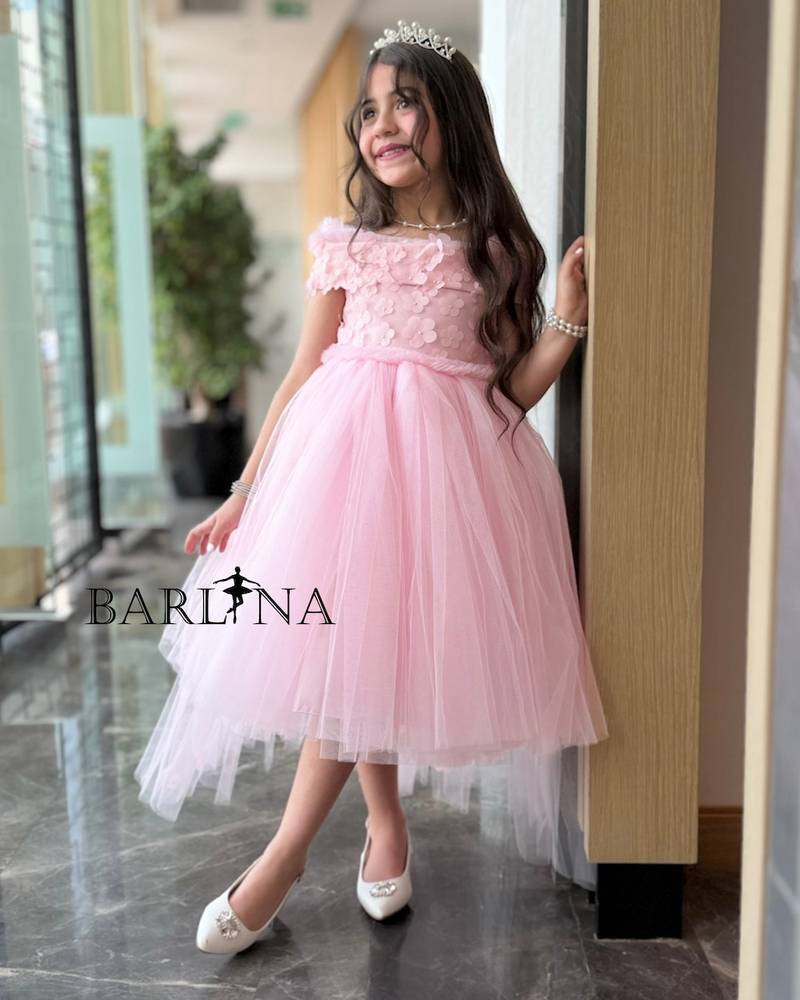 Pink girl's dress decorated with roses on the shoulder