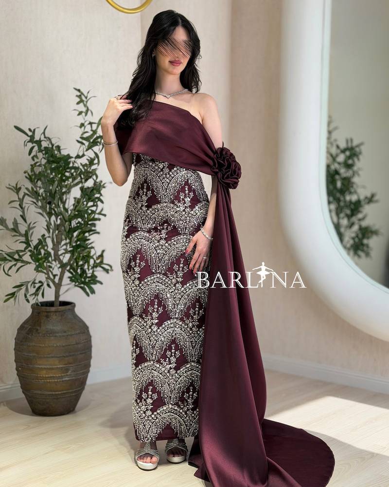 A burgundy dress with silver embroidery and a matching train.