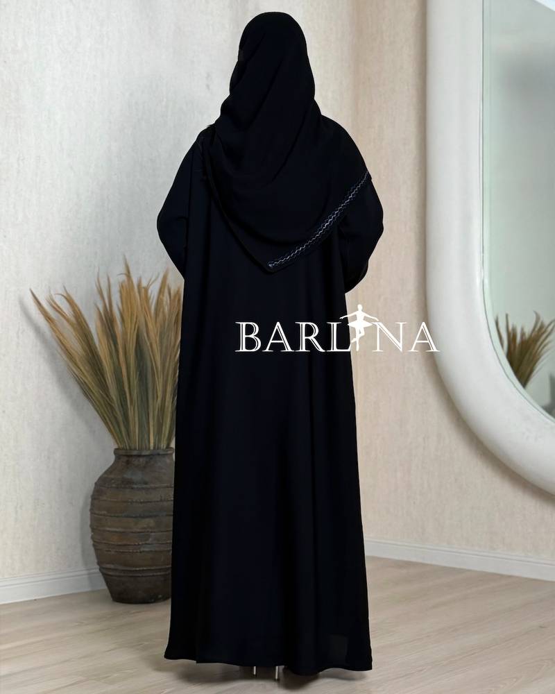 A black abaya decorated with gold embroidery