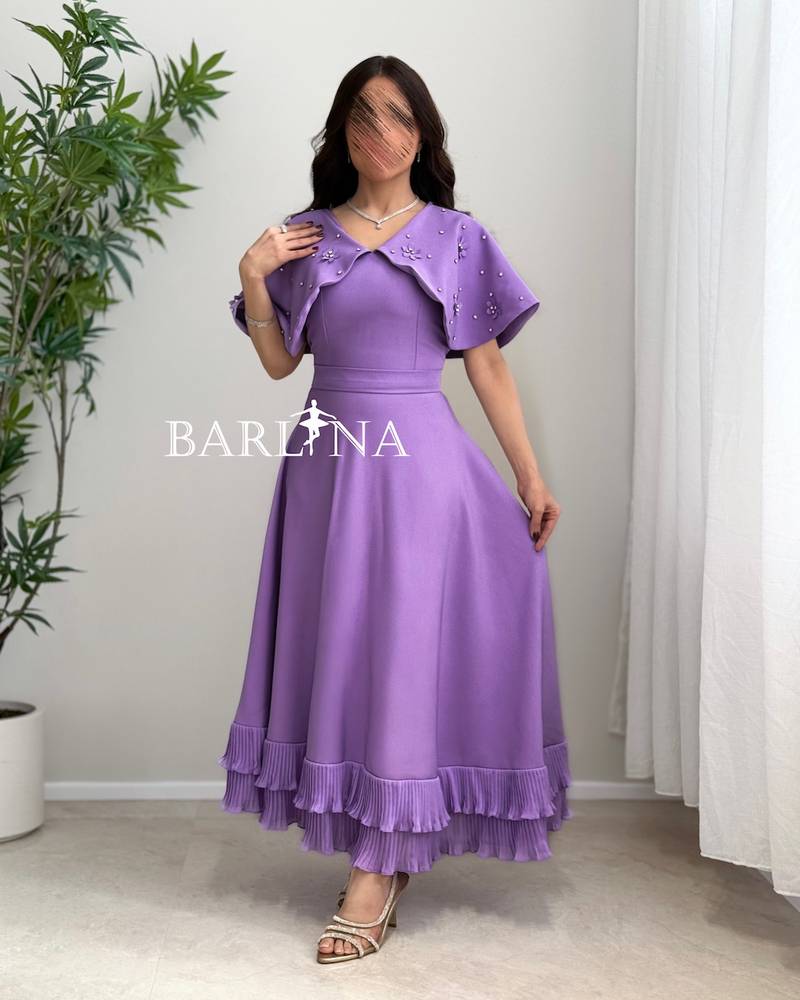 Dress with embroidered cape and pleats at the bottom