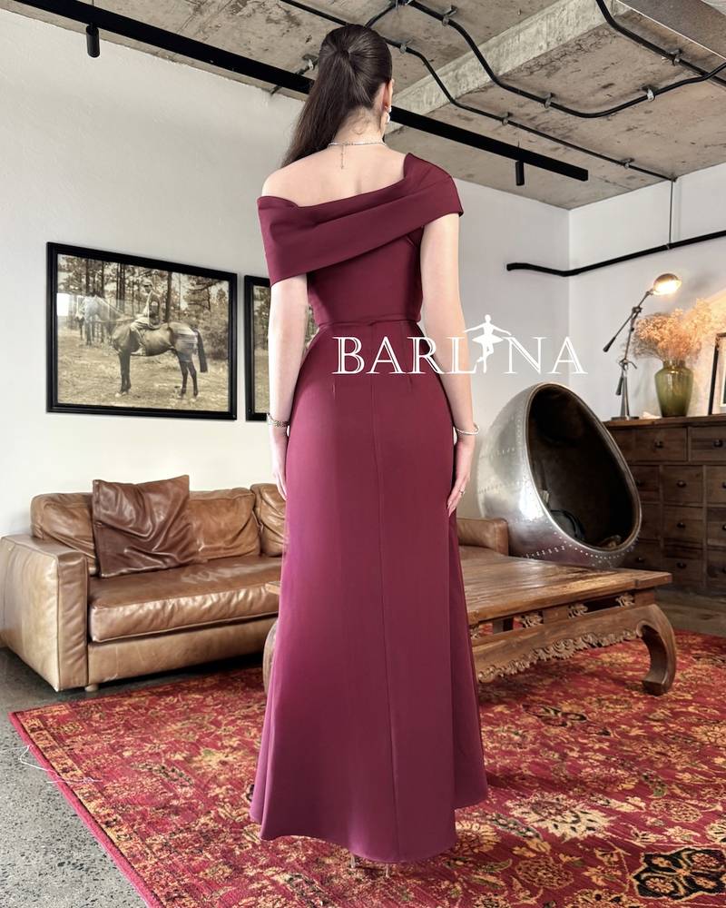 Long burgundy gown with a one-shoulder draped design