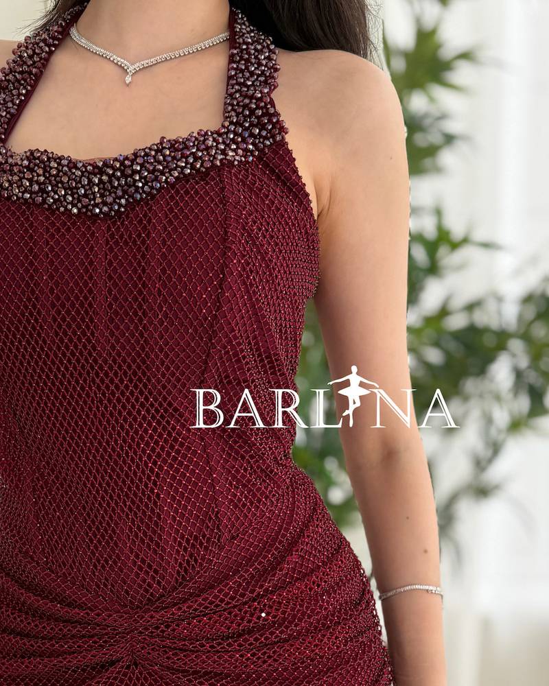 A long, elegant burgundy halter-neck dress