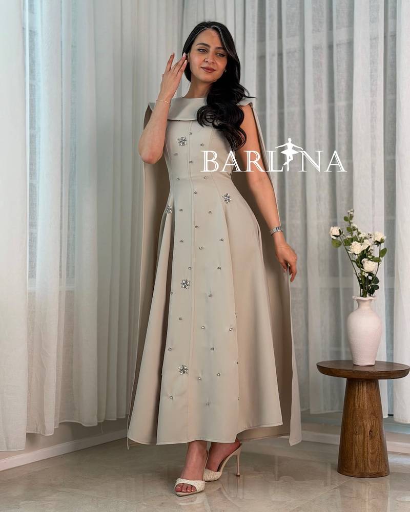 Beige dress with a cape design embellished with crystals