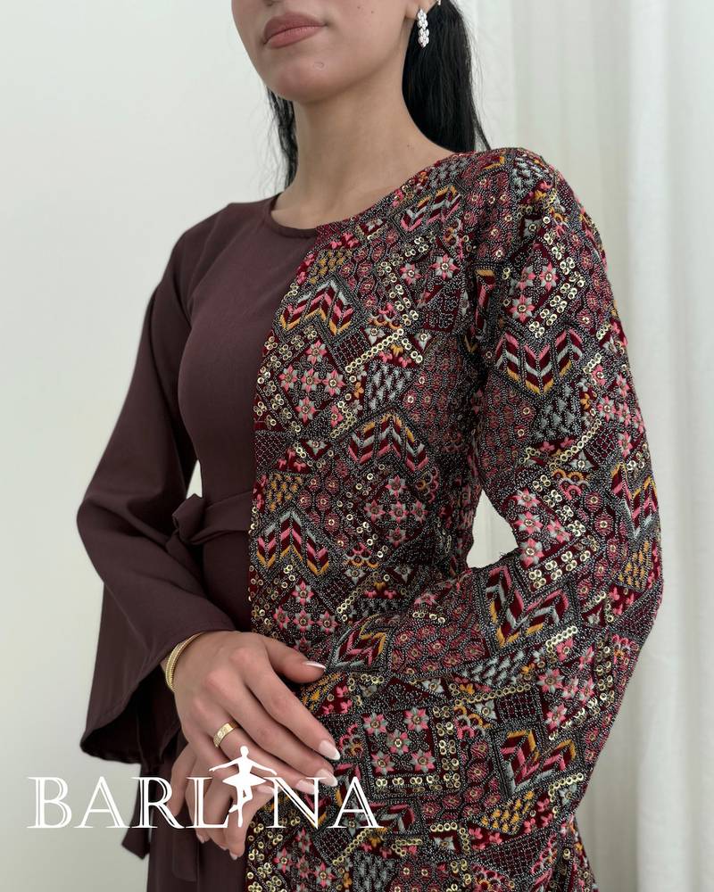A maroon djellaba with a colorful traditional pattern