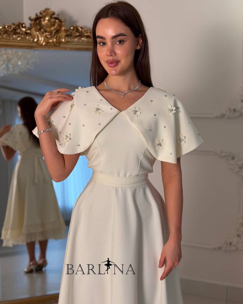 Dress with embroidered cape and pleats at the bottom