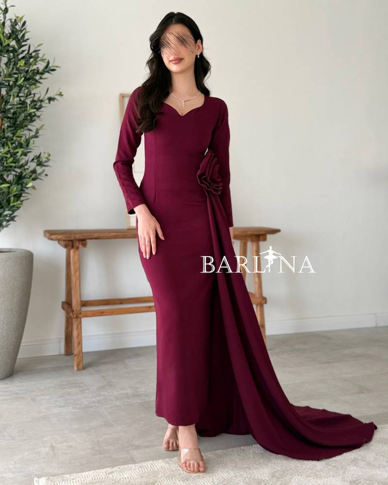 A purple dress adorned with a side flower and a long train.