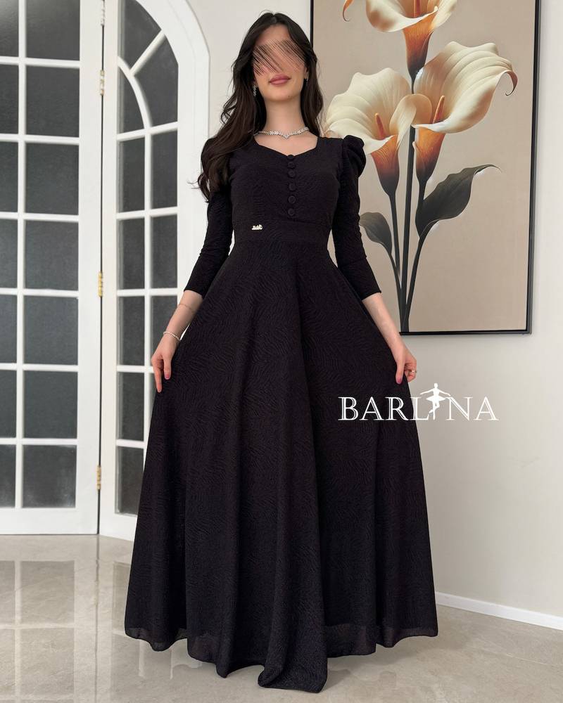 A black dress with a wide cut and elegant buttons