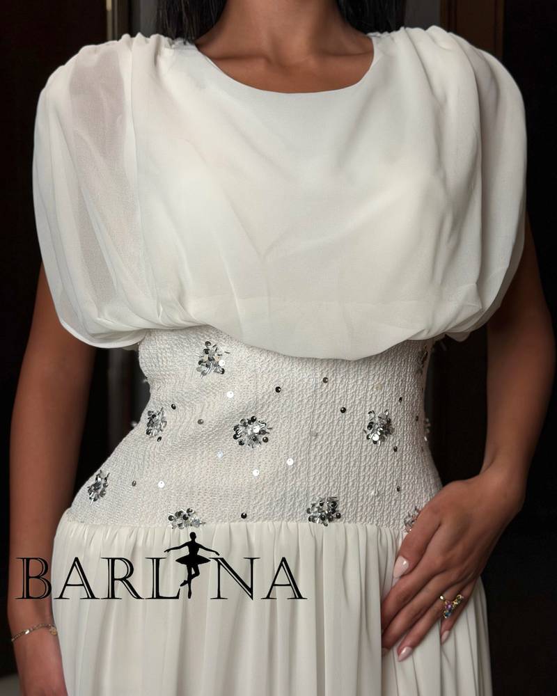 A soft white dress with a waist adorned with elegant details.