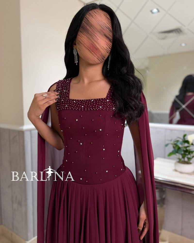 A flowy berry-colored dress with a royal long cape