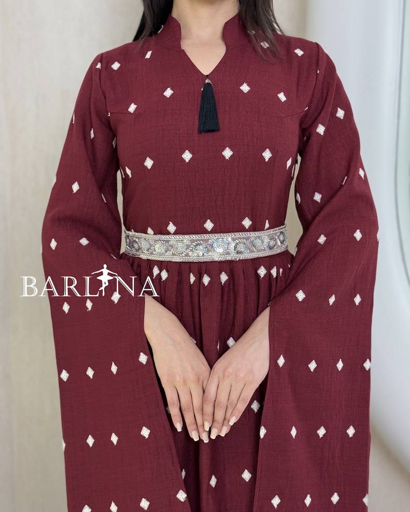 A burgundy-colored jalabiya with scattered patterns