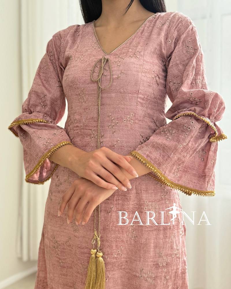 A soft pink jalabiya with gold trim